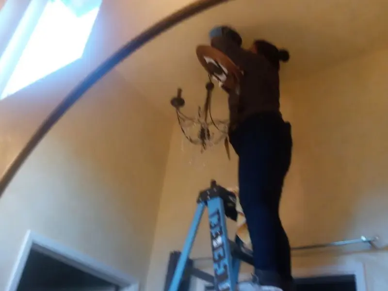 Electrician installing a chandelier in a Vienna residence